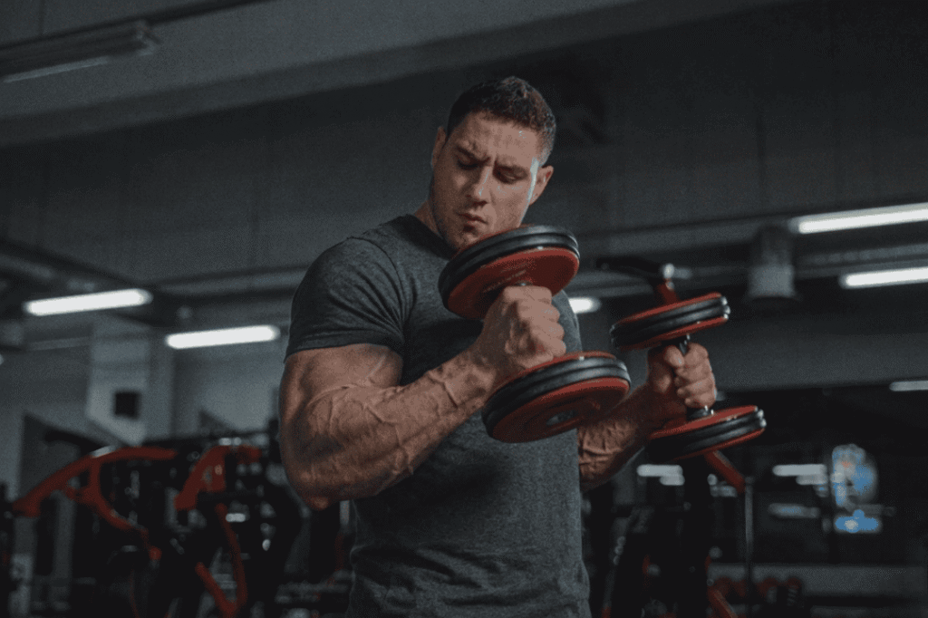 A man performing dumbbell lateral raises in the gym