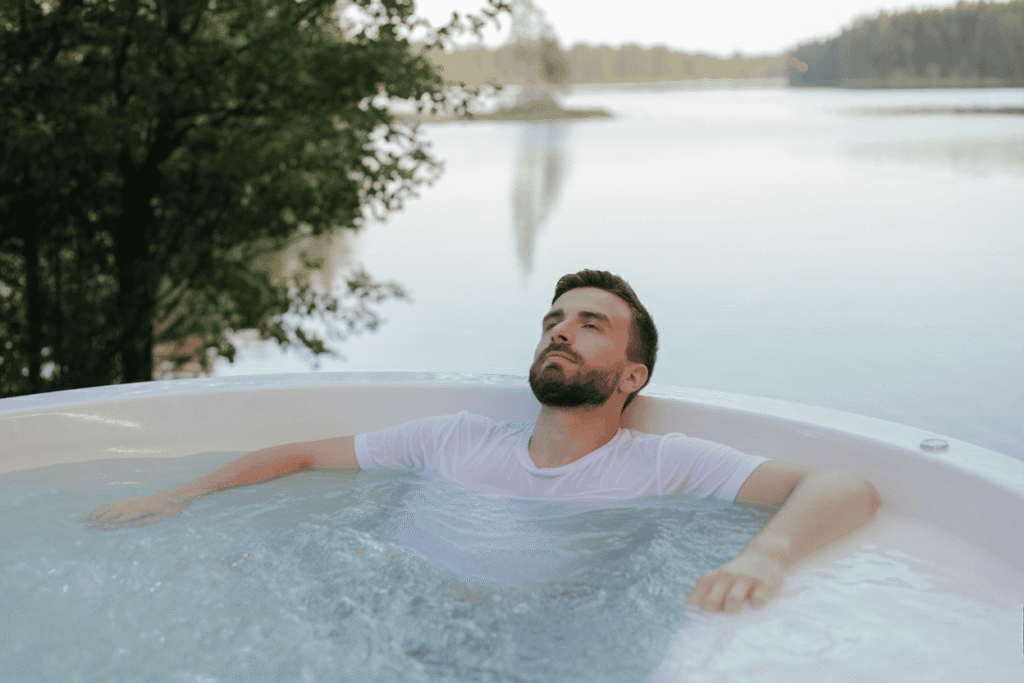 Man relaxing in a hot jacuzzi wearing a white t-shirt