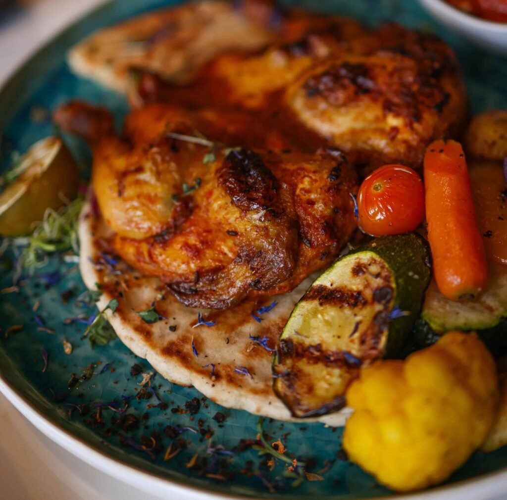 Baked Chicken Thighs with Roasted Vegetables Baked Chicken Thighs with Roasted Vegetables and lemon on a plate