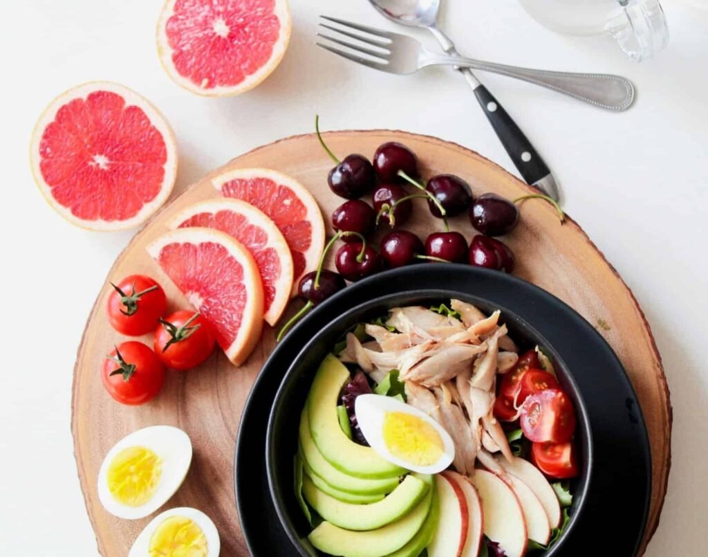 Healthy food includes tuna,eggs, avocado,tomato,apple, and Blood orange