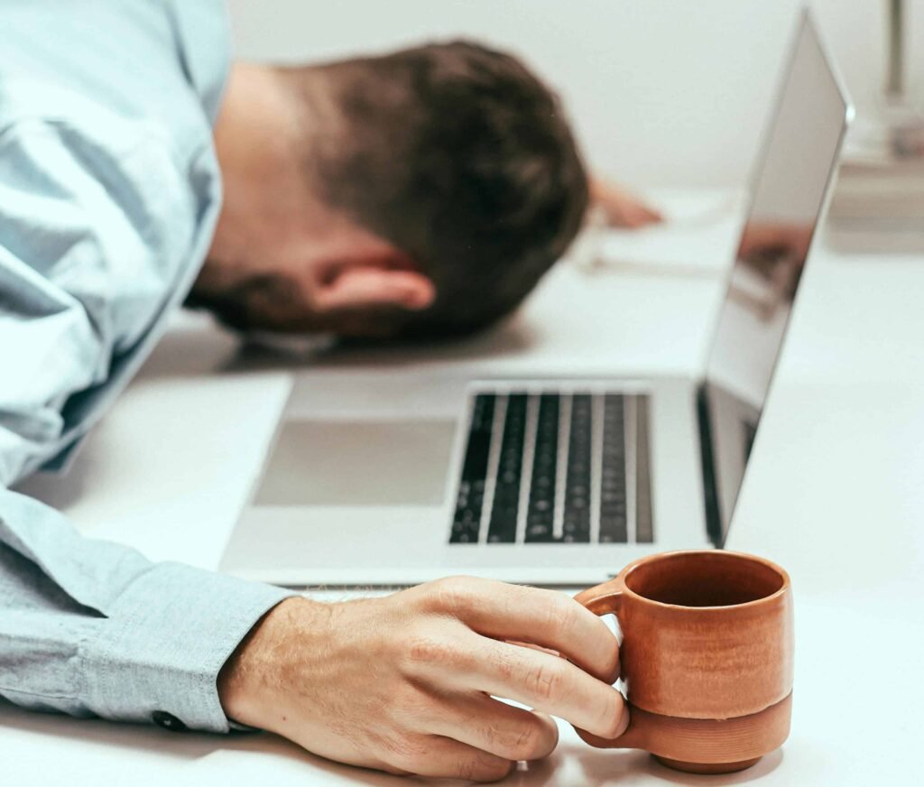 A tired man collapses on his desk