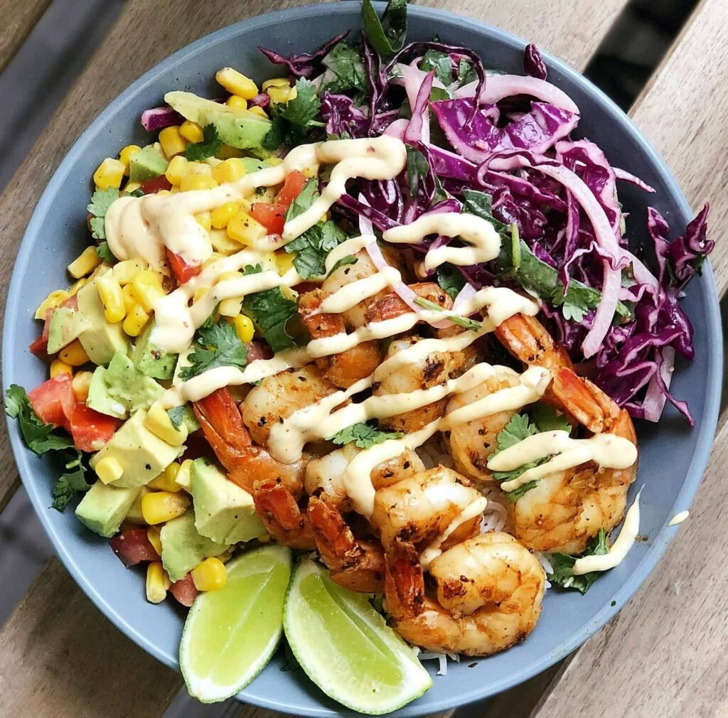 Grilled Shrimp with Avocado Salsa with corn, a high protein meal on a blue plate