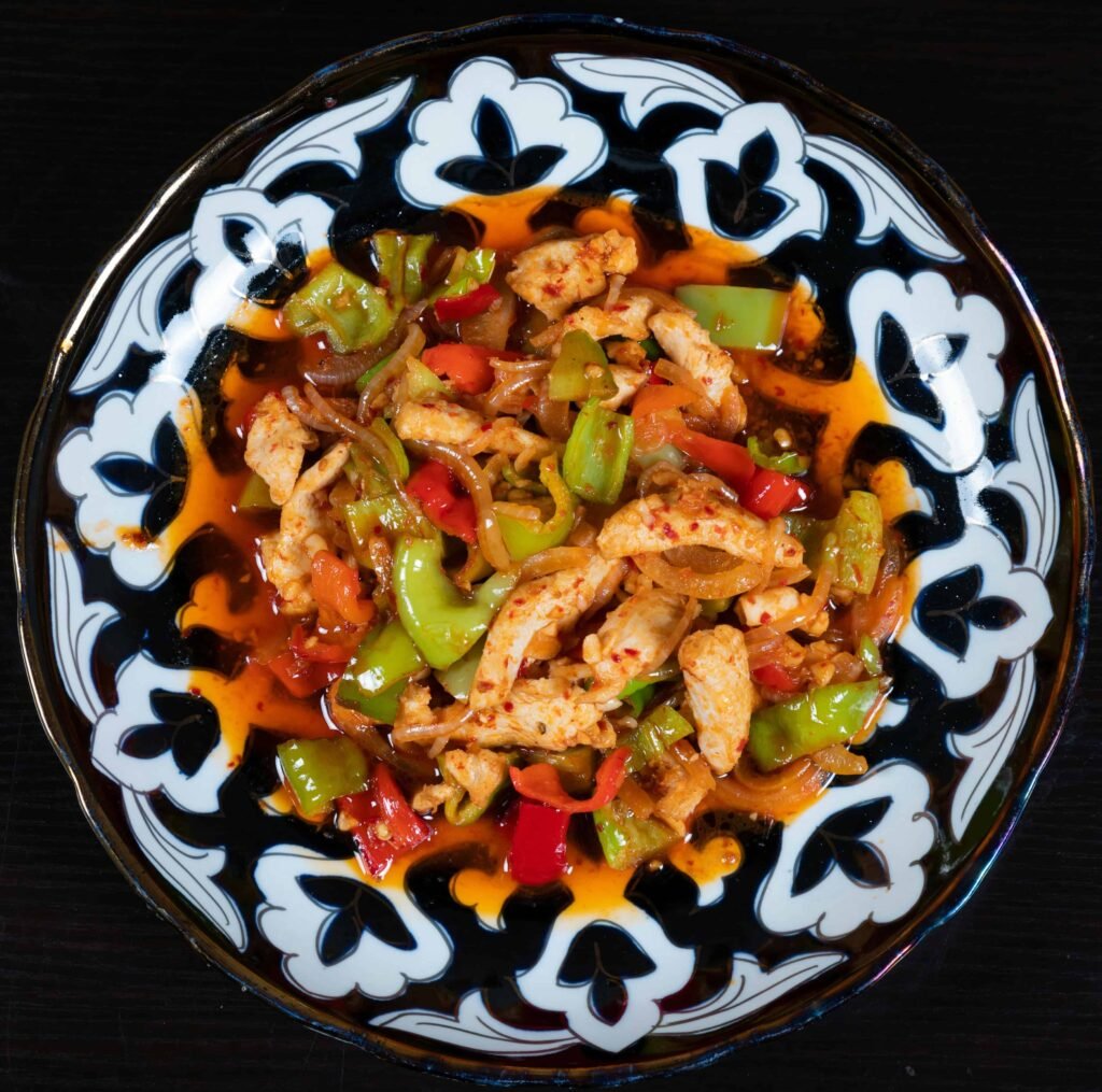 White and black plate with chicken and veggie